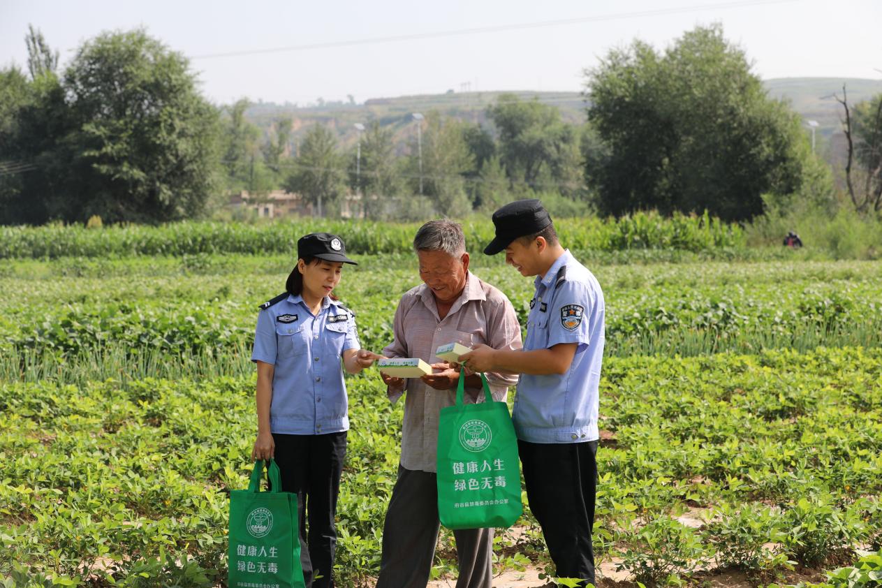 图为：民警深入田间地头开展禁毒宣传及森林防火宣传
